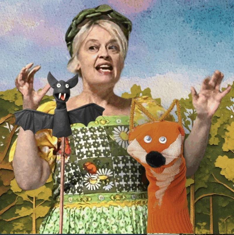 bernadette russell against a painted backdrop with a fox and a bat puppet